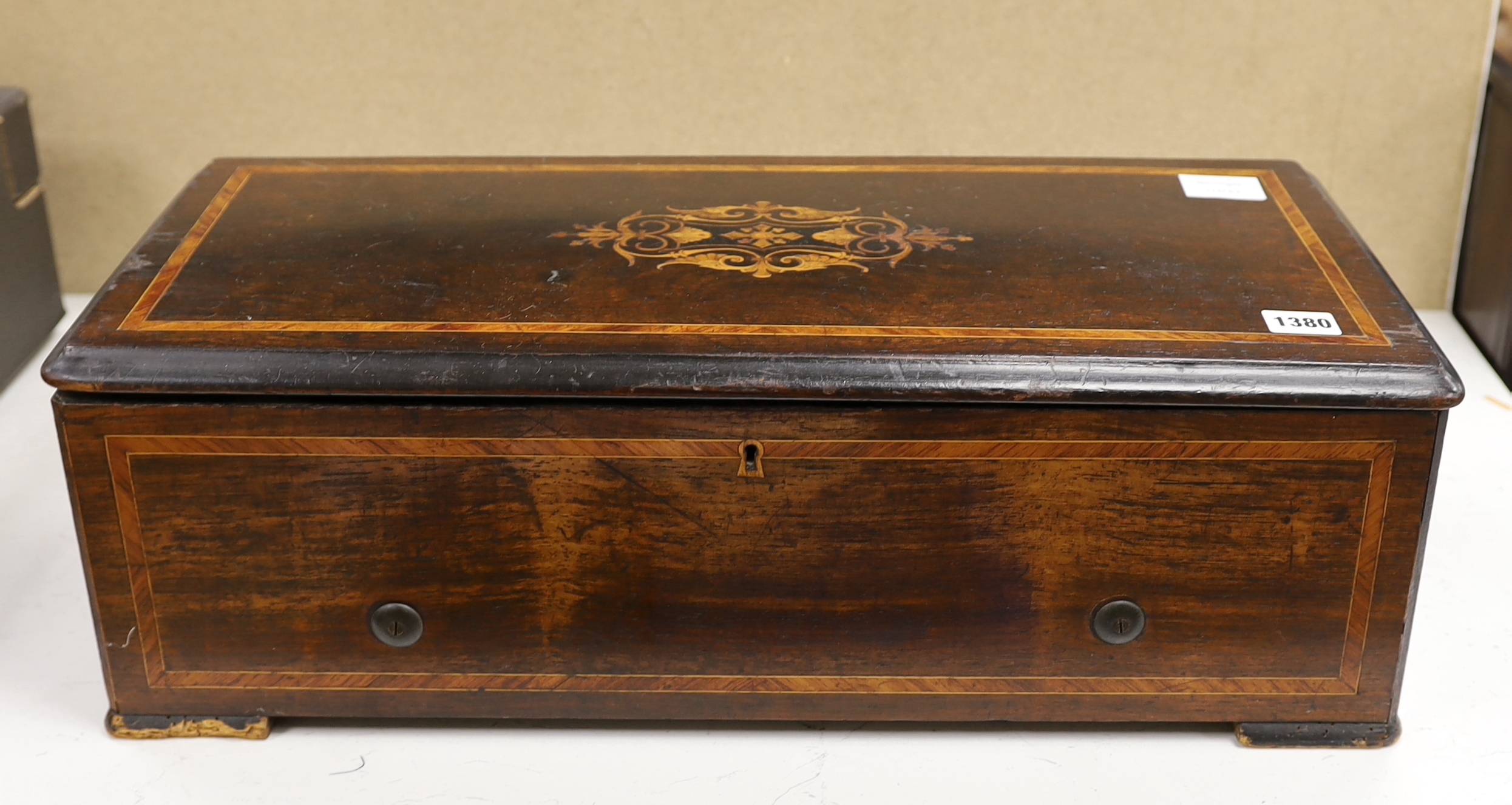 An early 20th century Swiss inlaid rosewood music box, requires restoration, 61cm wide x 19cm high